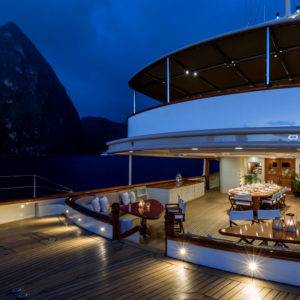 Lights shining on outside deck of NERO Yacht at night.