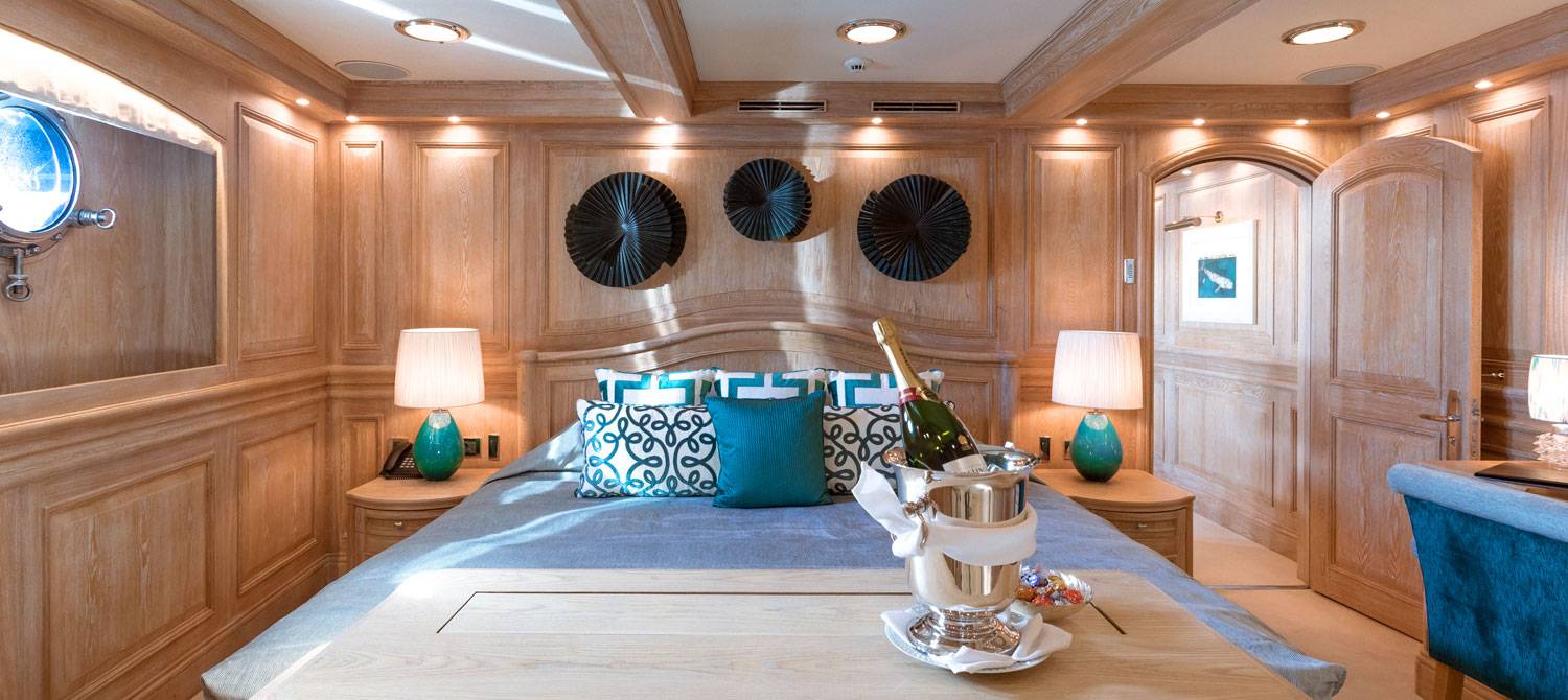 Bottle of champagne in front of the bed of the VIP suite on NERO Yacht.