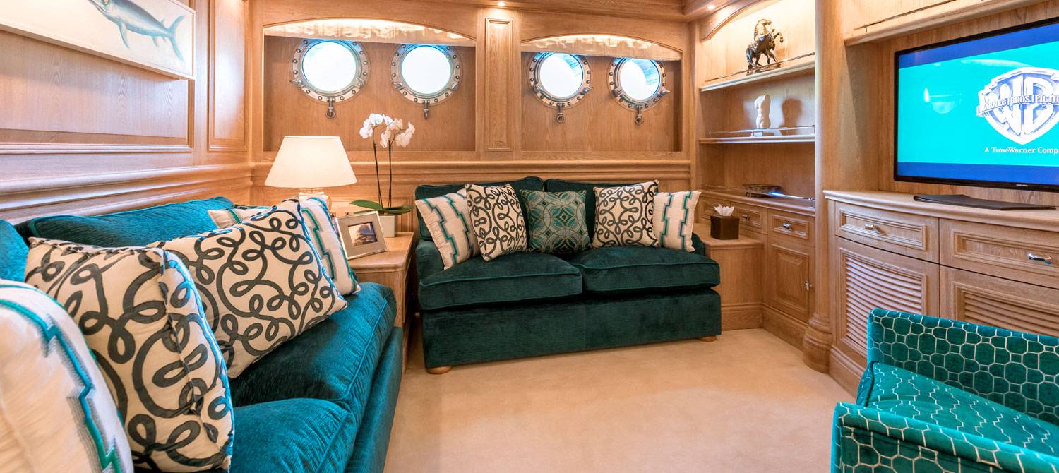 Green couches in the seating area of the VIP suite on NERO Yacht.
